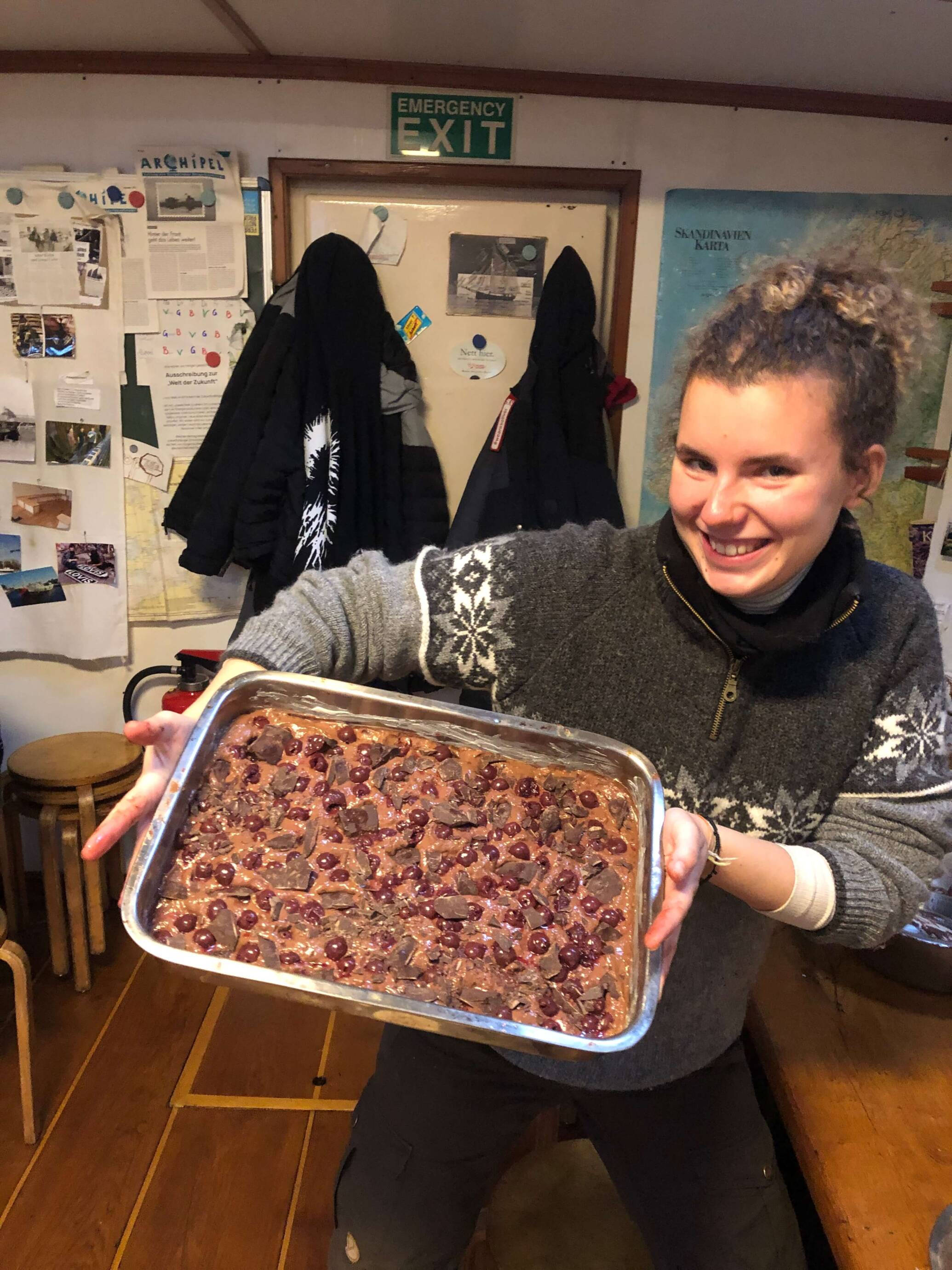 Person hält Kuchen mit Kirschen.